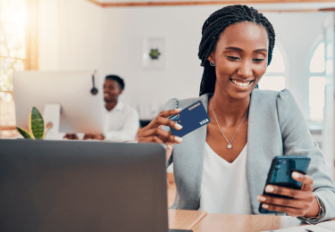 Mulher segurando cartão e celular